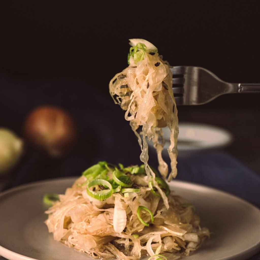 A mouthwatering plate of sauerkraut garnished with green onions, ready to eat.